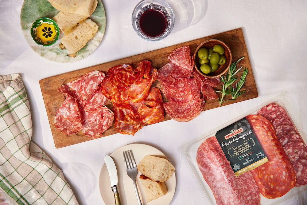 Rovagnati product photo of cured meats, green olives, rosemary, bread, and red wine, by Brooklyn-based food/drink photographer Trevor Baca.