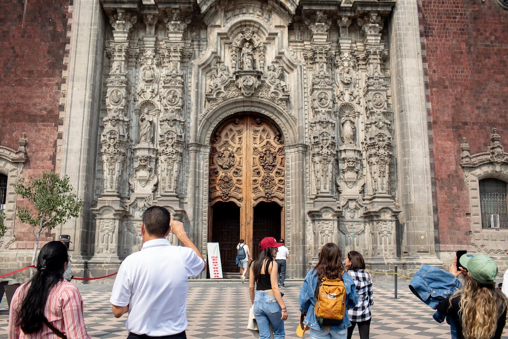 Photo of ornate stone church facade with large open wooden doors, by Mexico City-based travel photographer Andrew Reiner. 