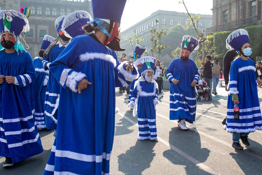 Photo of parade figures in traditional blue and white costumes with masks and headdresses, by Mexico City-based travel photographer Andrew Reiner. 