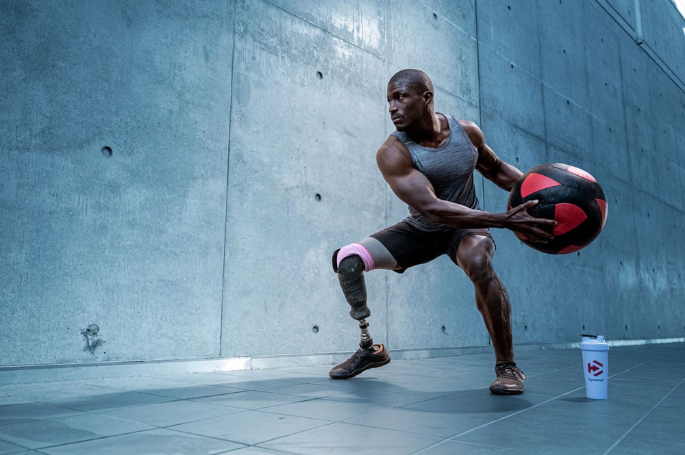 Athlete doing a squat holding a medicine ball for Dymatize nutrition supplement brand. 