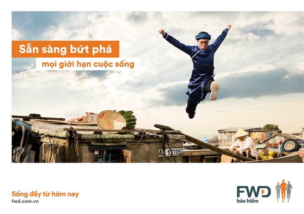 Tear sheet of runner in blue traditional Vietnamese garment. leaping from first story roof, by Vietnam-based Lifestyle Photographer Tim Gerard Barker. 