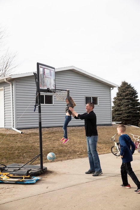 As part of a social documentary photography project about evangelical voters, Ackerman and Gruber took this image of a man playing basketball in his driveway with his two young children.