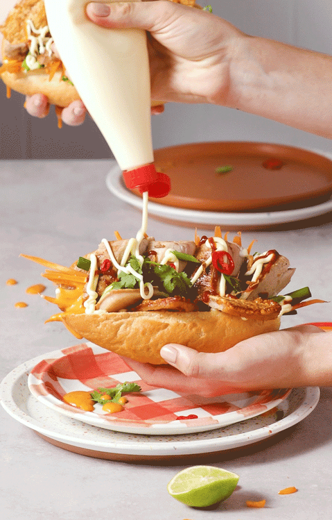 Gif by Andre Martin of hands holding sandwiches being topped with mayonnaise.