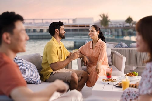 A couple enjoys drinks and snacks by the water in Abu Dhabi, image captured by London photographer Tom Parker.
