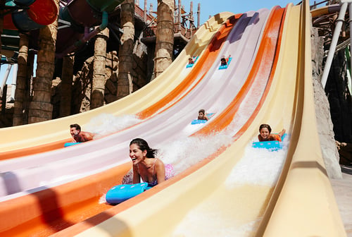 A family slides down together at a water park in Abu Dhabi, taken by photographer Tom Parker.