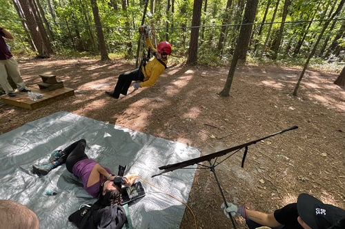 behind the scenes shot of a person riding a zipline
