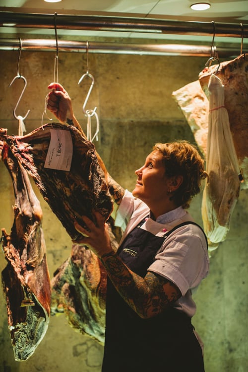 Photo by James Horan of a butcher hanging a slab of meat.