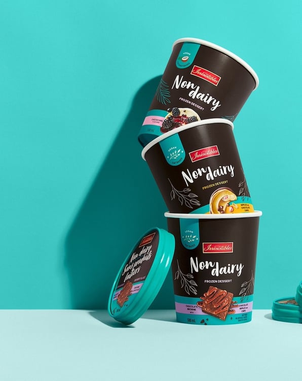 Photo of non-dairy frozen dessert containers stacked in a tower, before a shadowed teal backdrop, by Montreal, Canada-based food/drink photographer David De Stefano.