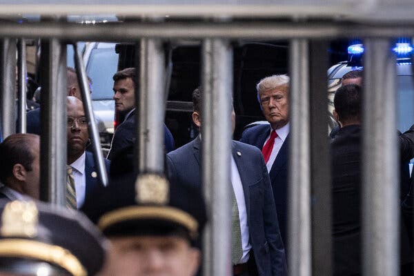 Donal Trump seen through metal scaffolding bars on the day of his arraignment. Image captured by Benjamin Norman for the New York Times.