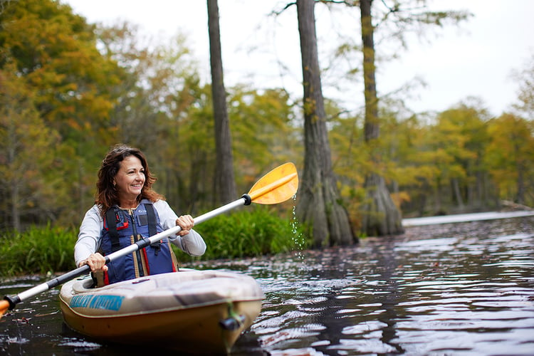 Woman kayaks in autumn on a marsh in Fayetteville, North Carolina.