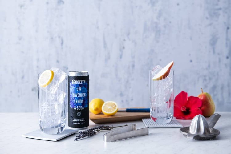 Photo by Michael Marquand of a canned cocktail next to ice-filled glasses and sliced lemons. Brooklyn Gin, canned gin, gin, alcohol, canned drinks, cocktail, drink, Michael Marquand, beverage photography, product photography, beverage photographer, product photographer
