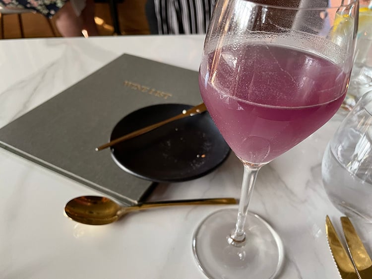 An image of a cocktail in a wineglass on a table in a restaurant that inspired Stephanie's color palette.