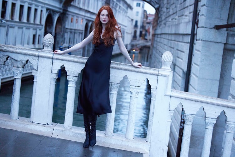 Photo by Guido Stazzoni of a woman in a black dress standing on a bridge in Venice.