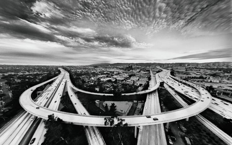 Photo by Saam Gabbay of a large split yet perfectly symmetrical highway in black & white.