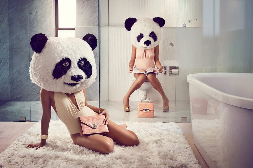 Shot from commercial handbag production featuring two models' heads replaced with panda heads.