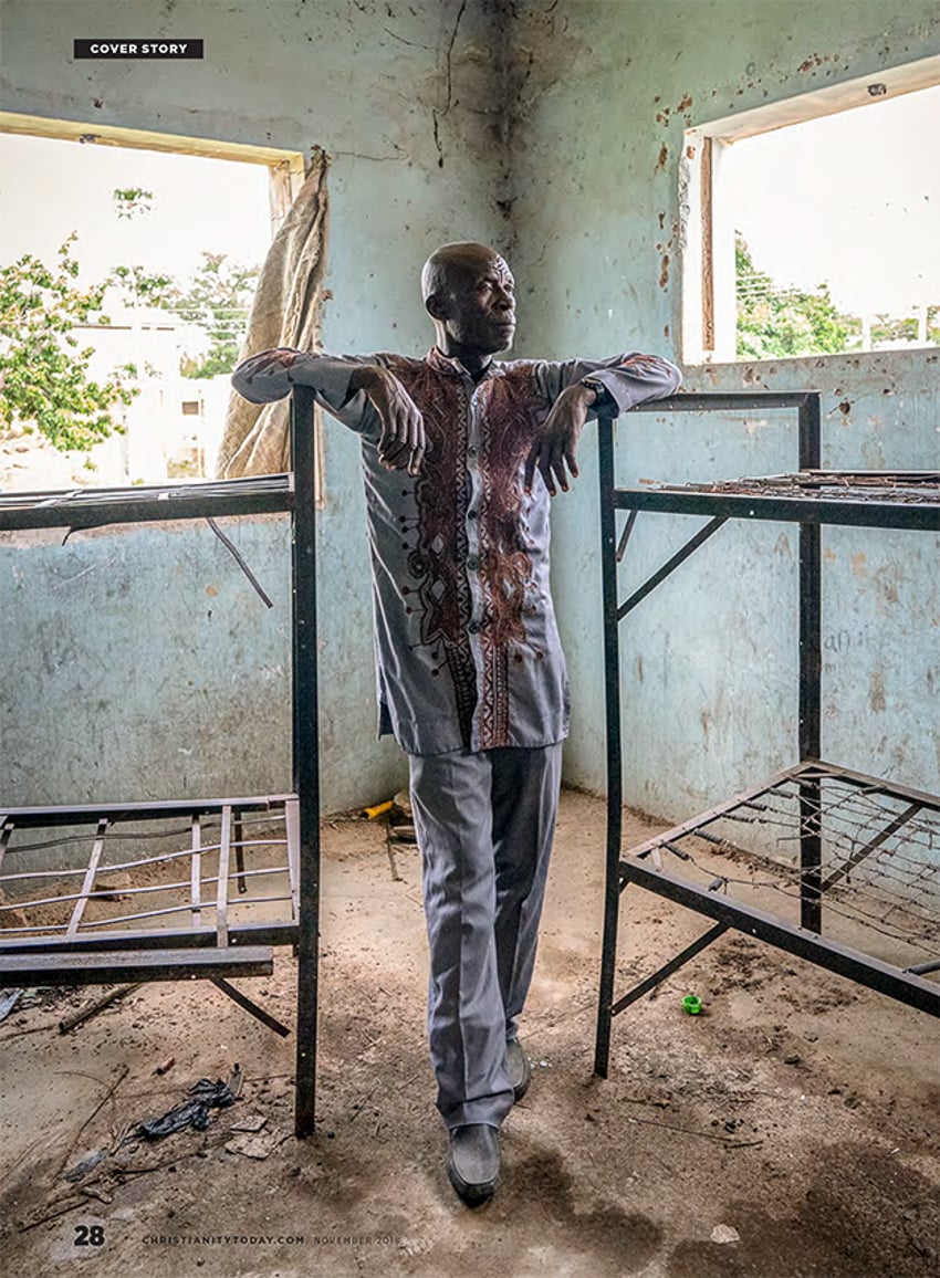Photograph of a man standing between two old, broken bedframes in an IDP camp by Gary Chapman on Nigeria's Unrelenting Terrorist Group Violence for Christianity Today.