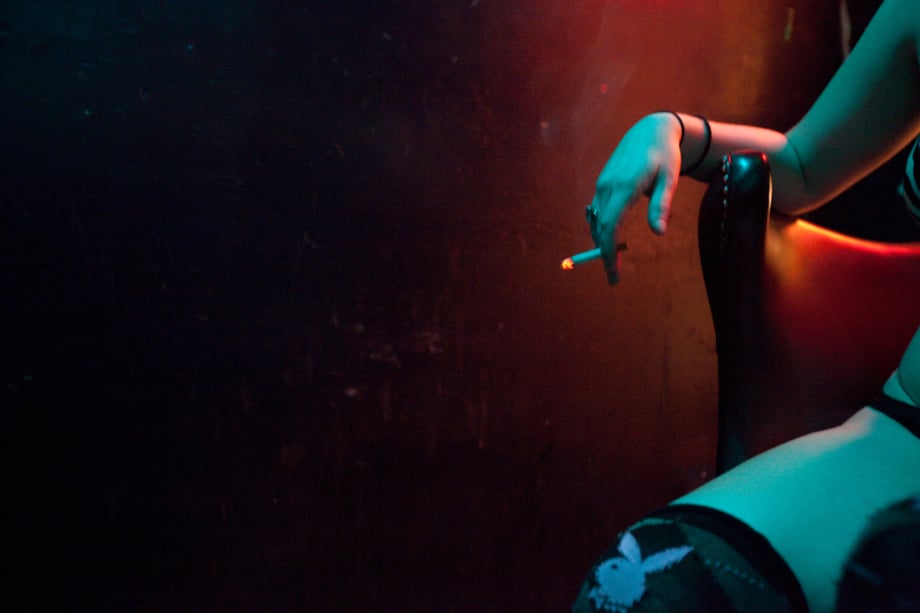 A performer smoking a cigarette at the strip club shot by Mexico-based photojournalist Alicia Vera 