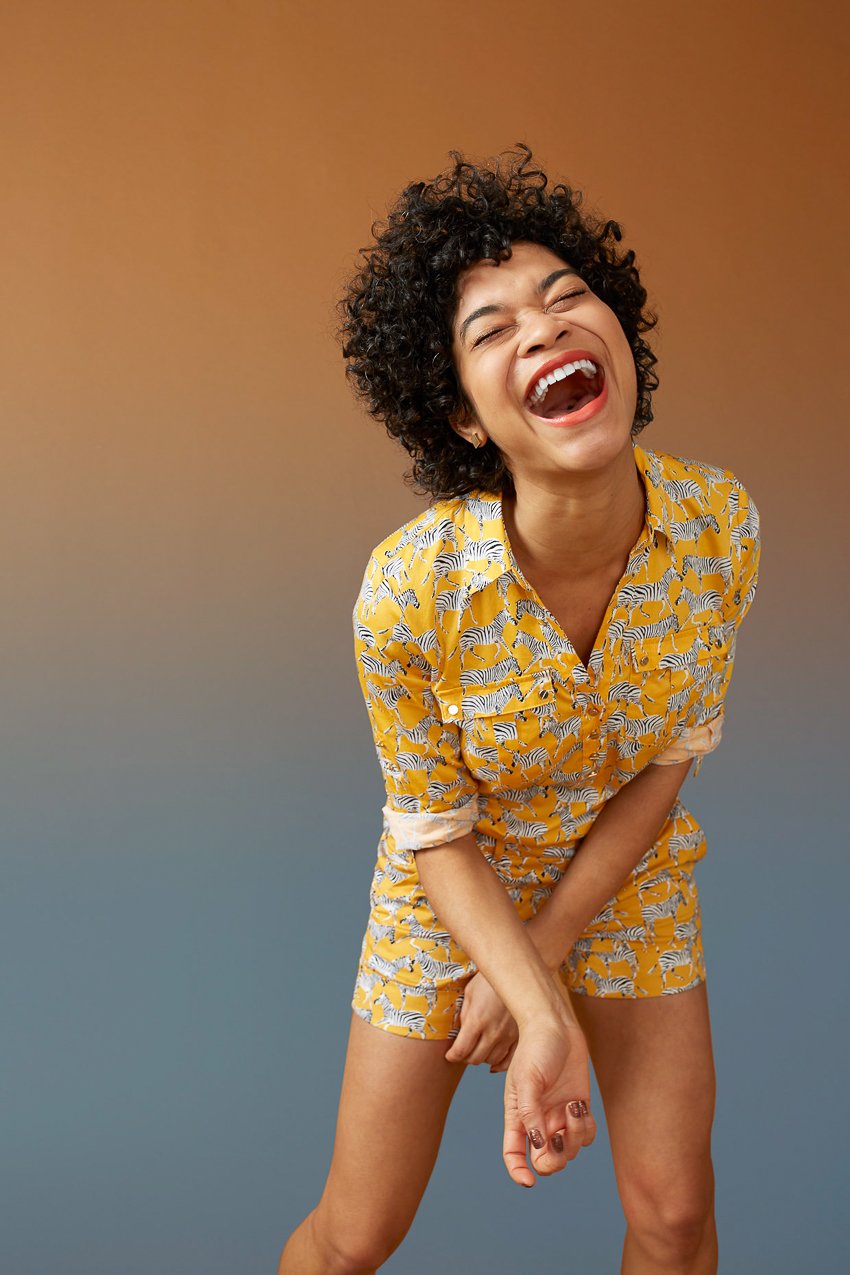 Photo of a woman laughing in front of a yellow background for the Color is Everything Seattle Art Museum project.