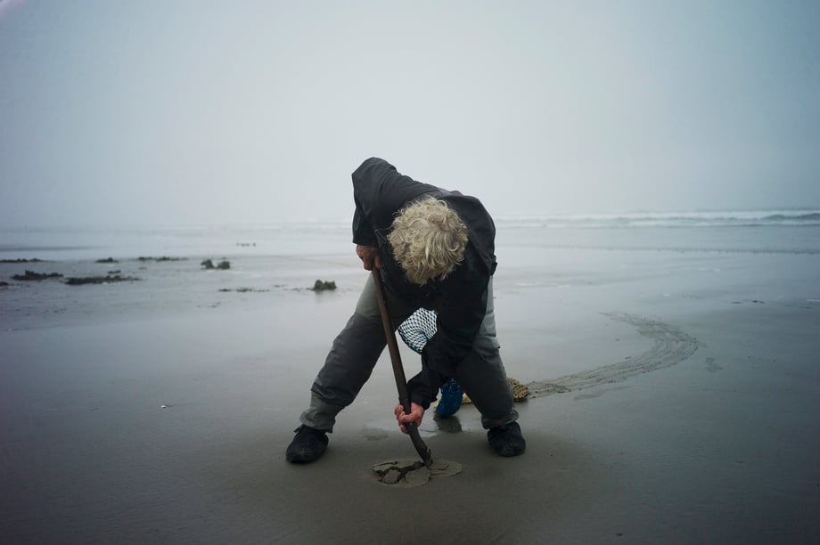 Richard Darbonne captures clam harvester Ron Neva sticking his small shovel deep into the sand for 1859 magazine