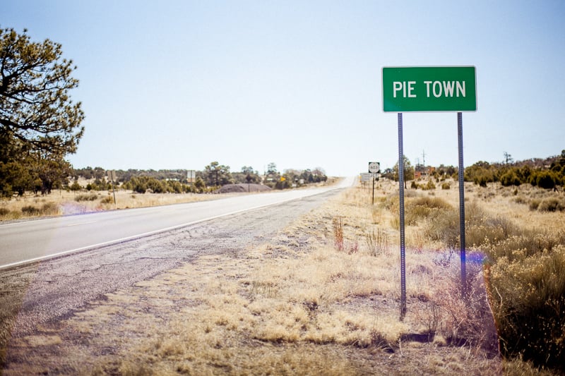 A landscape picture of a sign for Pie Town on an empty street, taken by Alan Gastelum