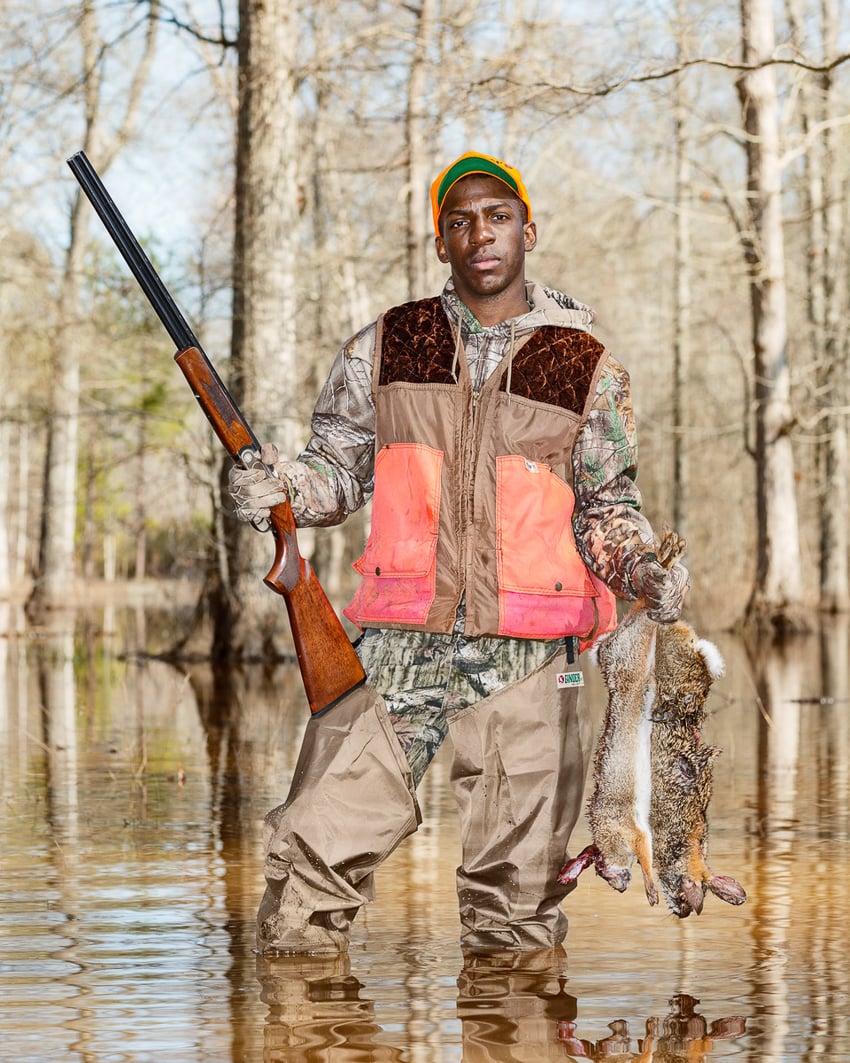 Tremayne Benson holding swamp rabbits on hunting trip in photo by Giacomo Fortunato