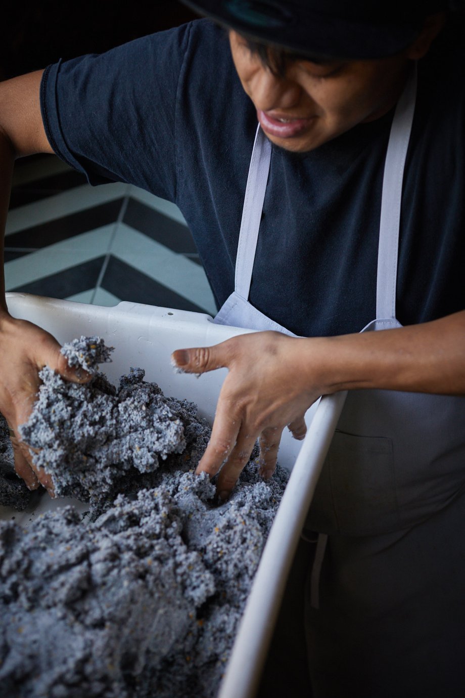 Jody Horton snaps a shot of a kitchen employee mixing blue corn masa with his hands in a large tray