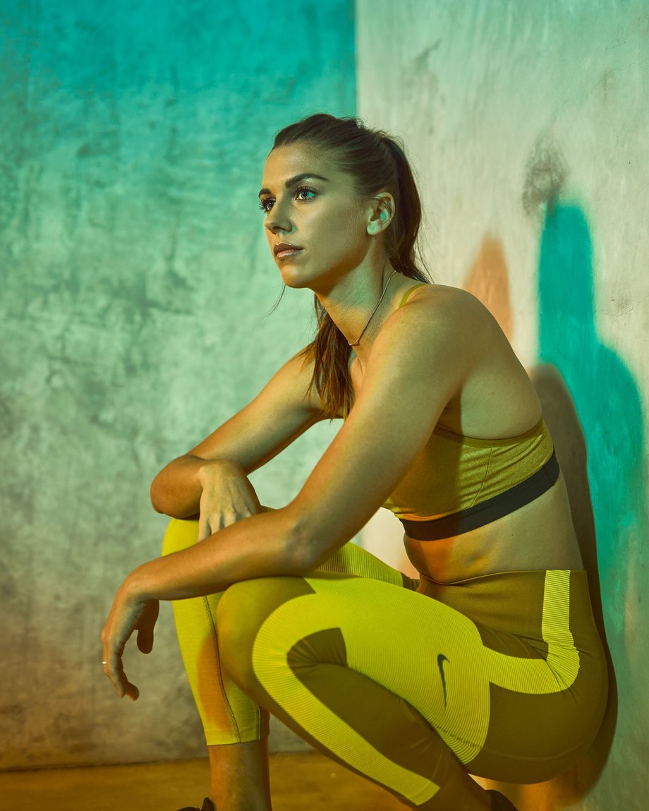 World class athlete Alex Morgan is crouched down against a wall in Mary Beth Koeth's portrait.