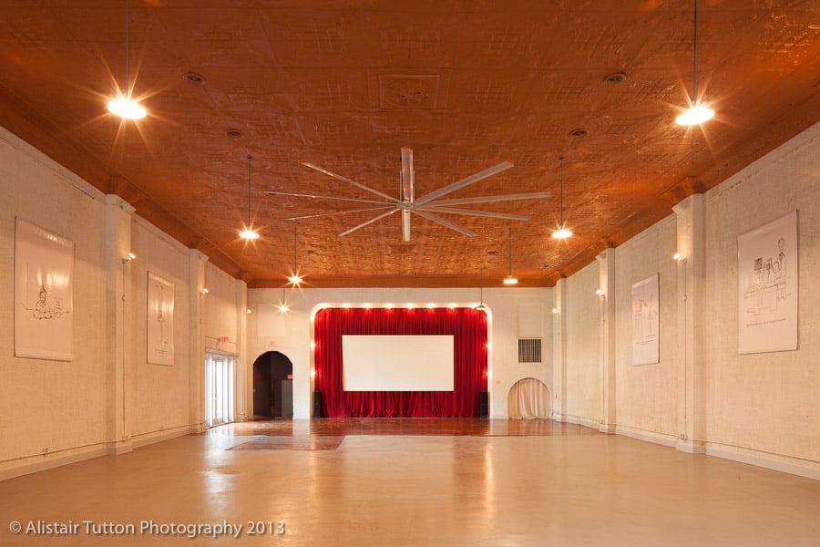 Alistair Tutton's studio interior  shows a large room with a screen and stage at the far end