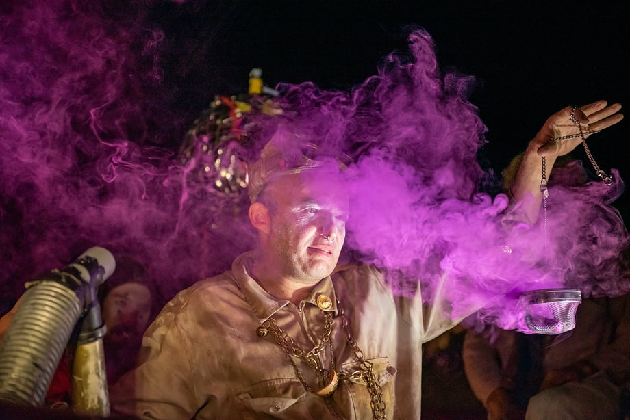 Arik Shraga Photographs a man shrouded in a mysterious purple smoke during a performance by DAVAI Theater Group