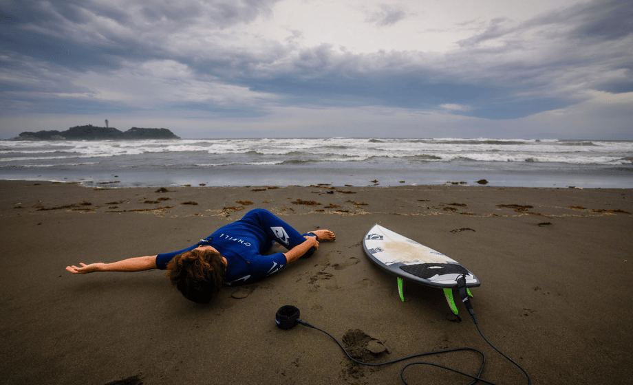 Ben Weller photographs a surfer stretching before getting in the water for Hana Hou!