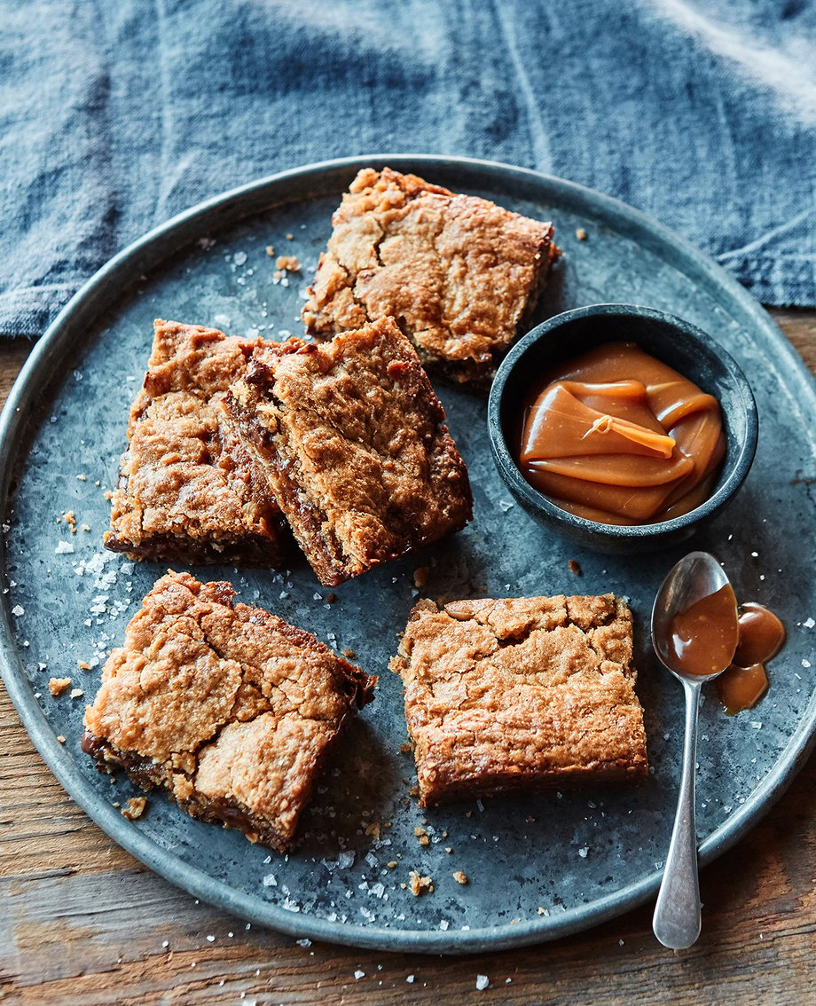 Maria's baked bars sit on a blue plate with a little cup of dipping caramel in this photo by Colin Price