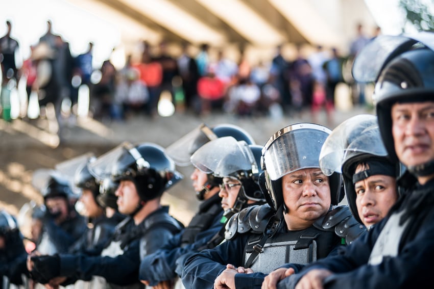 Sean Rayford Image of Central American Migrants and a line of armed guards