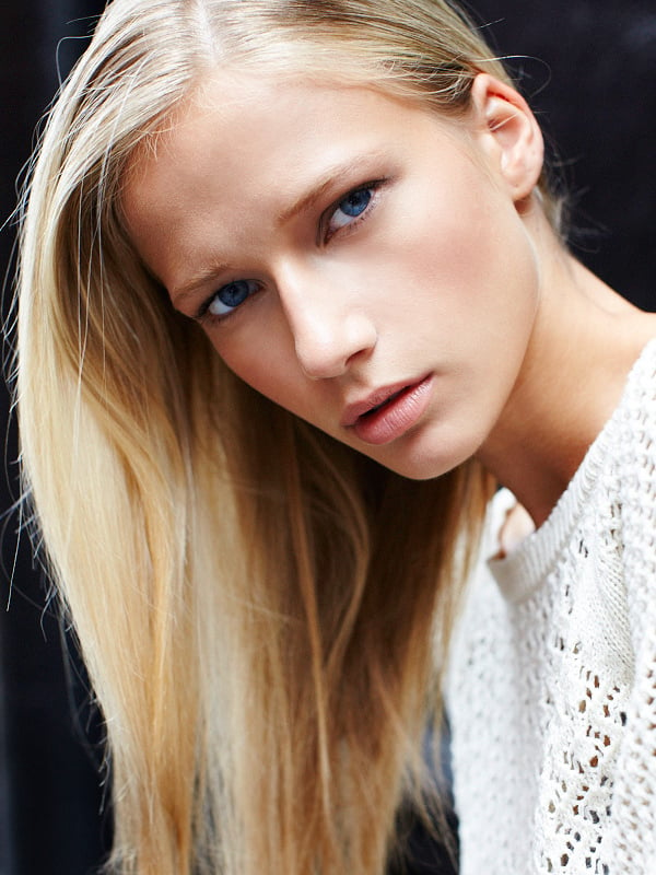Close-up of woman with long blonde hair and blue eyes, wearing a white sweater shot by New York-based fashion photographer Joshua Pestka
