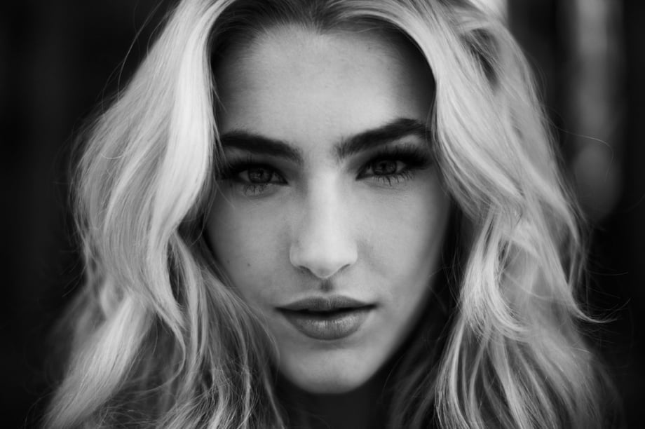 Black and white close up of a woman with long blonde hair shot by New York-based fashion photographer Joshua Pestka