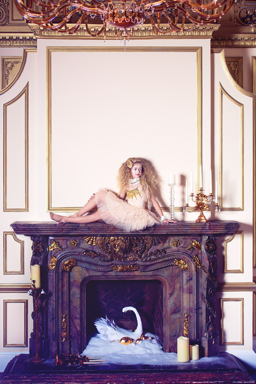 A girl seated on top of a fireplace, photograph by Megan Dendinger