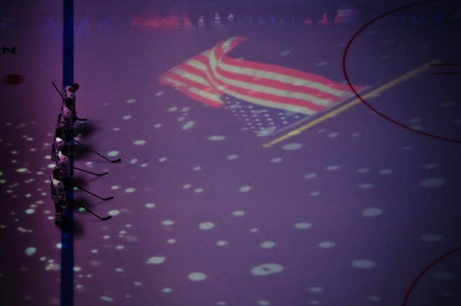 Hockey players on the ice beside a projected American flag shot by Dallas-based portrait photographer Trey Hill for Dallas Star Sports