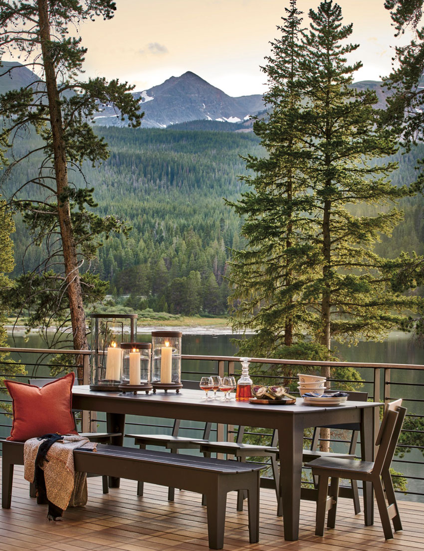 David Patterson shoots for Luxe Magazine from the house's deck, facing the water and a tree-covered mountain 
