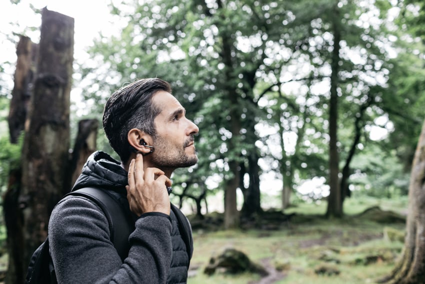Man using Sony Xperia ear in a forest photographed by Ashley Lewis