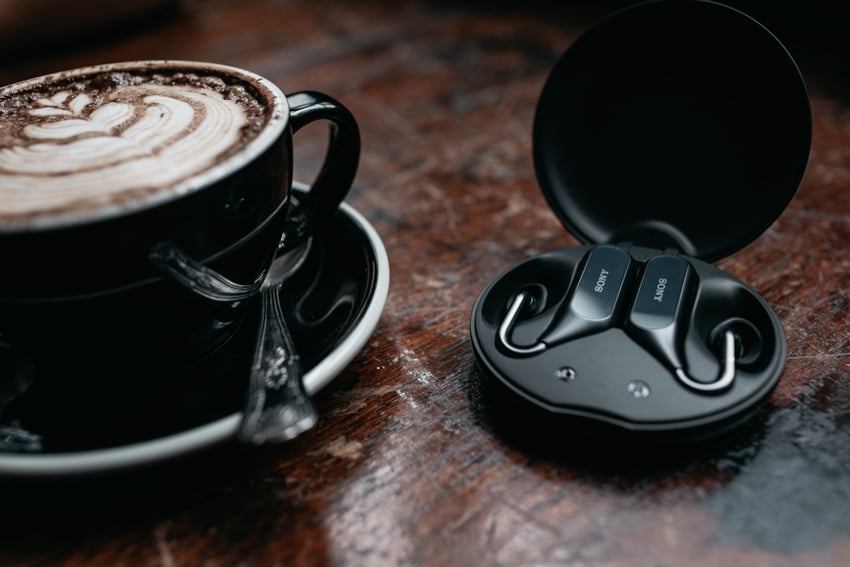 Cup of coffee and Sony Xperia ear on a wooden table photographed by Ashley Lewis