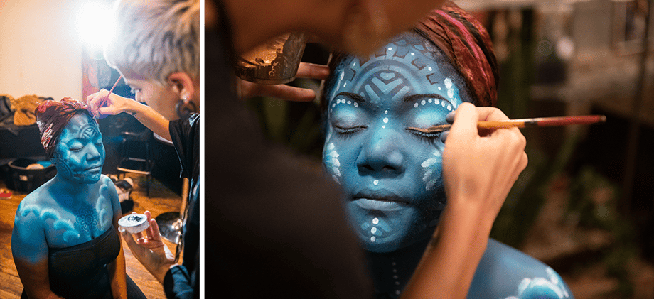 Two behind the scenes shots by Julia Lehman show Angie adding face and body paint to Olivia, who portrayed Mami Wata