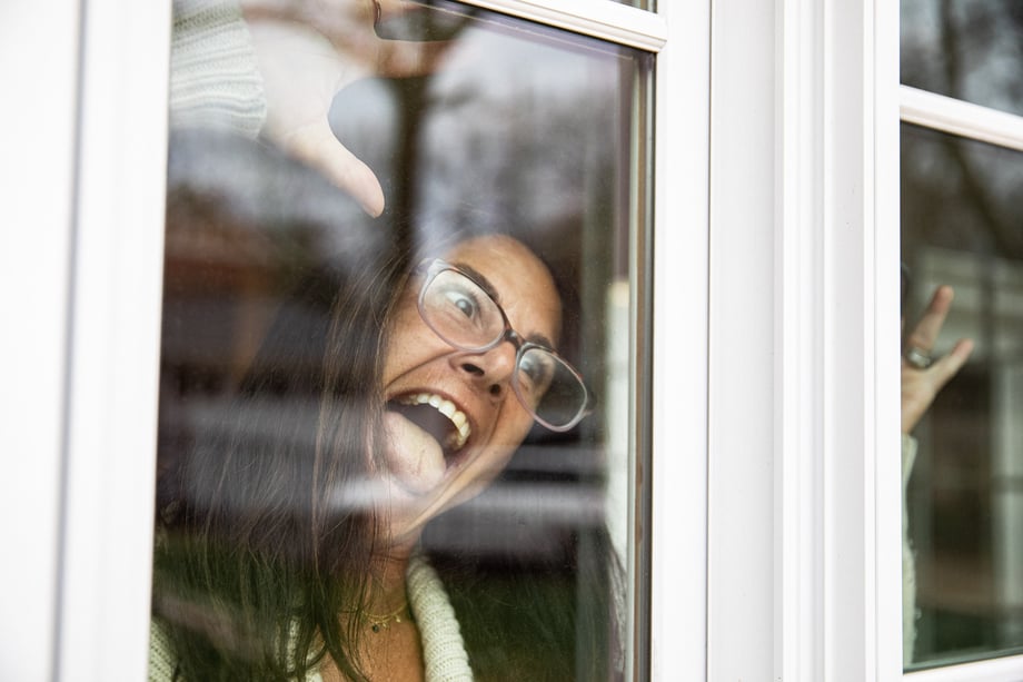Photo of woman making a goofy face through her window.