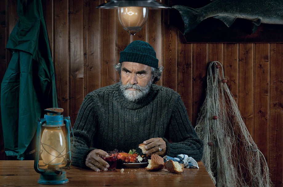 Image of a haggard fisherman eating a meal and surrounded by fishing paraphernalia by Francesco Ridolfi.