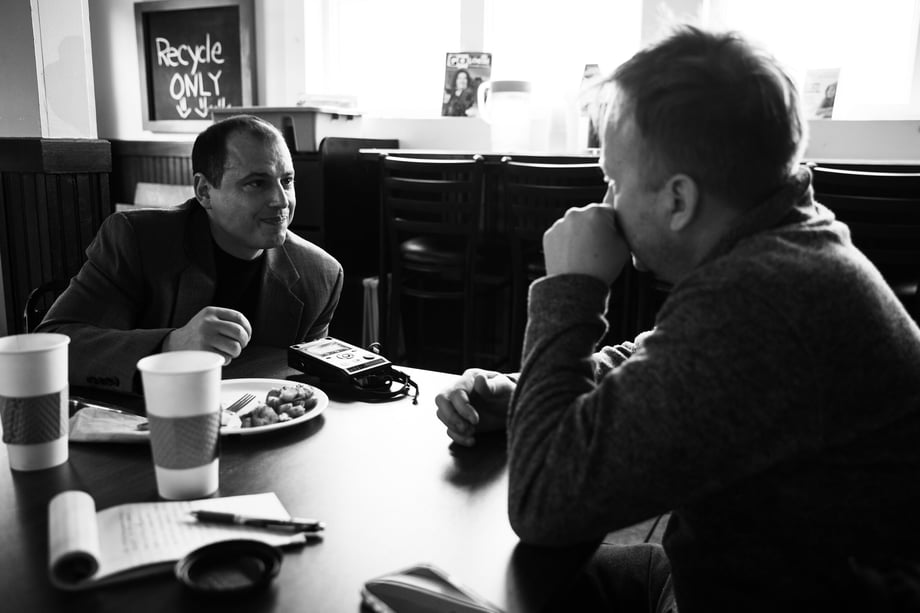 Black and white behind the scenes photo of Hannaford interviewing Arillotta in a diner