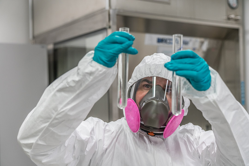 A Janssen chemist in protective wear compares test tubes. 
