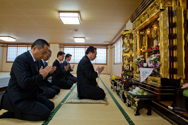 Yakuza kneeling in temple, photographed by Christopher Jue for The Times of London.