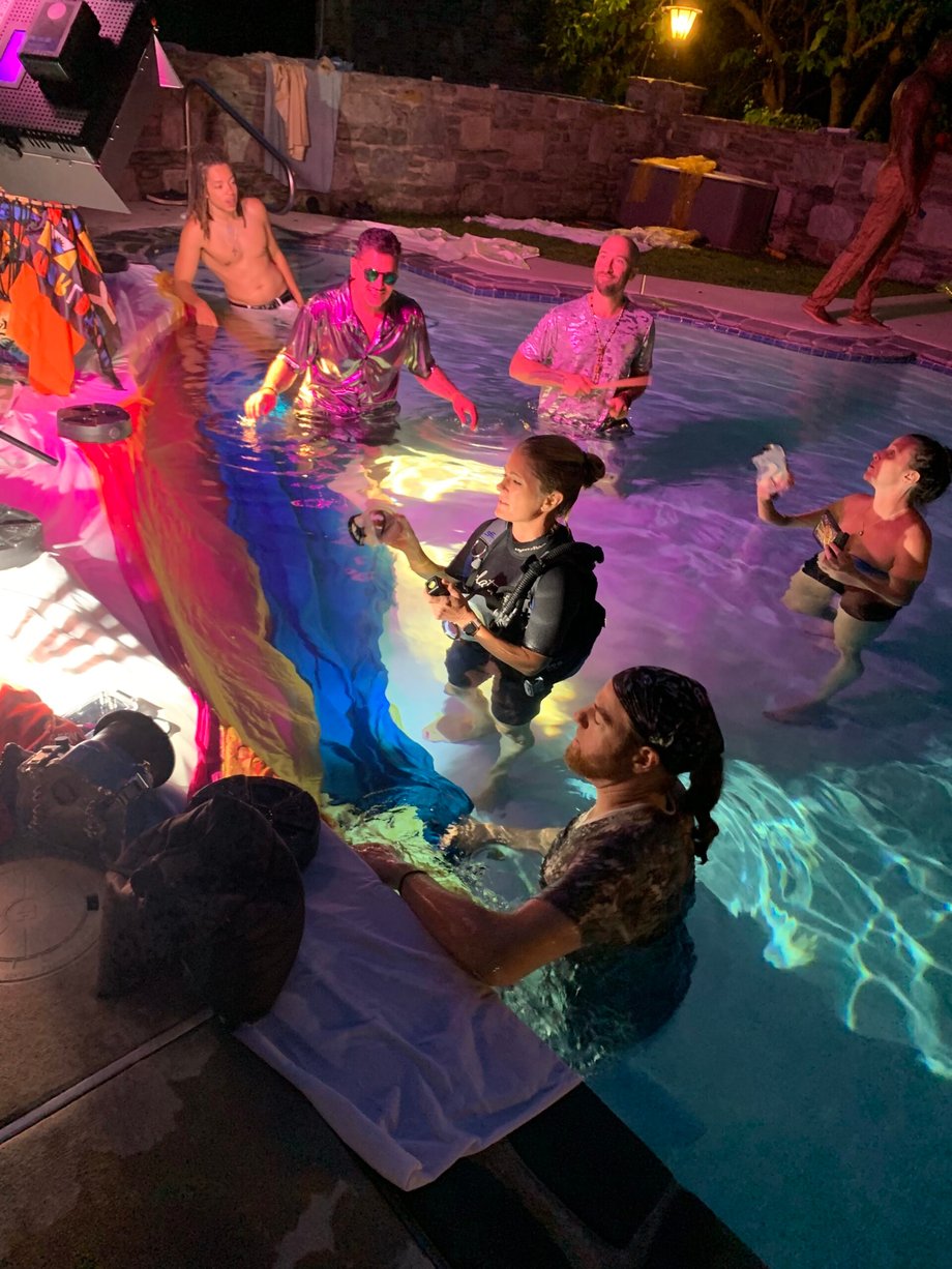 Behind the scenes at the shoot shows Julia Lehman's in the pool with several crew members