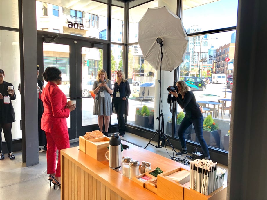 Behind the scenes shot shows Sara Stathas as she photographs Starbucks COO Roz Brewer