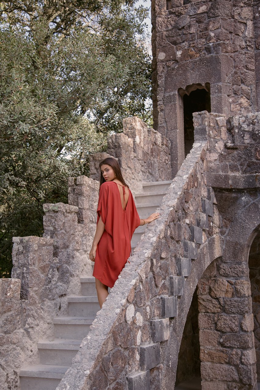 Photo of a woman walking up the steps to a castle for Raven + Lily.