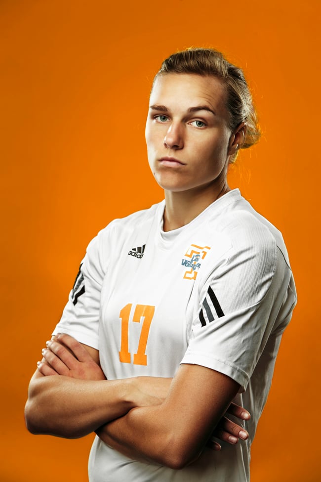 Portrait of a University of Tennessee athlete in uniform with an orange background.