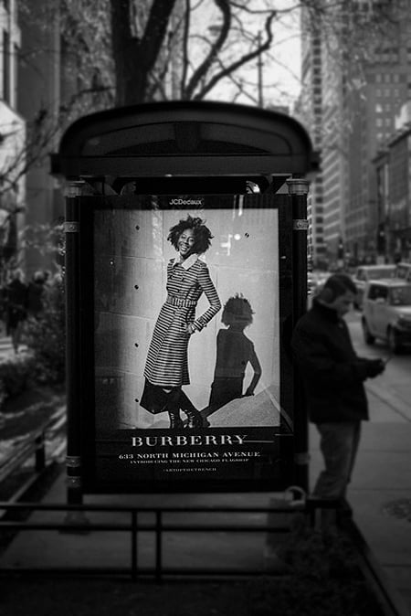Tim Klein's image of a woman in a trench coat used as an ad for Burberry on the side of a bus stop